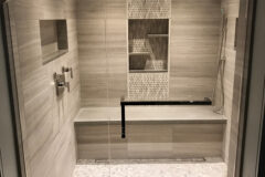 Shower Walls: 12′′ × 24′′ Limestone tile, horizontal straight pattern. Shower Bench & Curb: Quartz. Left Niche: Quartz ledge with flat polished edge. Center Niche: Limestone, vertical subway mosaic pattern, in Cherry Hills, Colorado